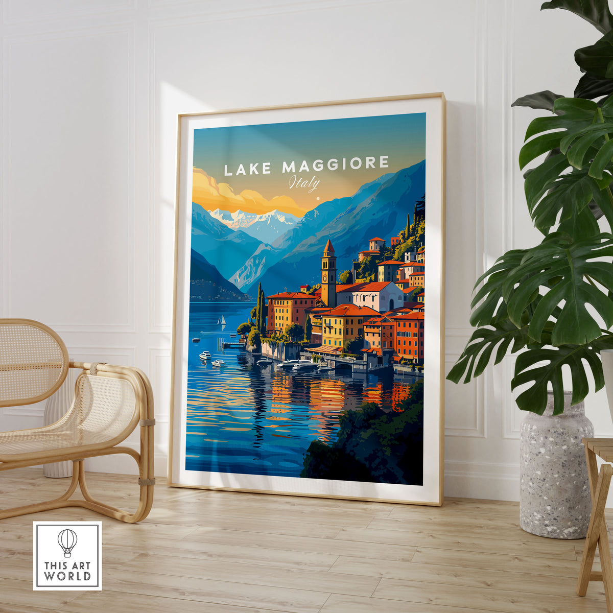 Lake Maggiore Print in a large natural wood frame leaning in a room with a rattan chair and monstera plant