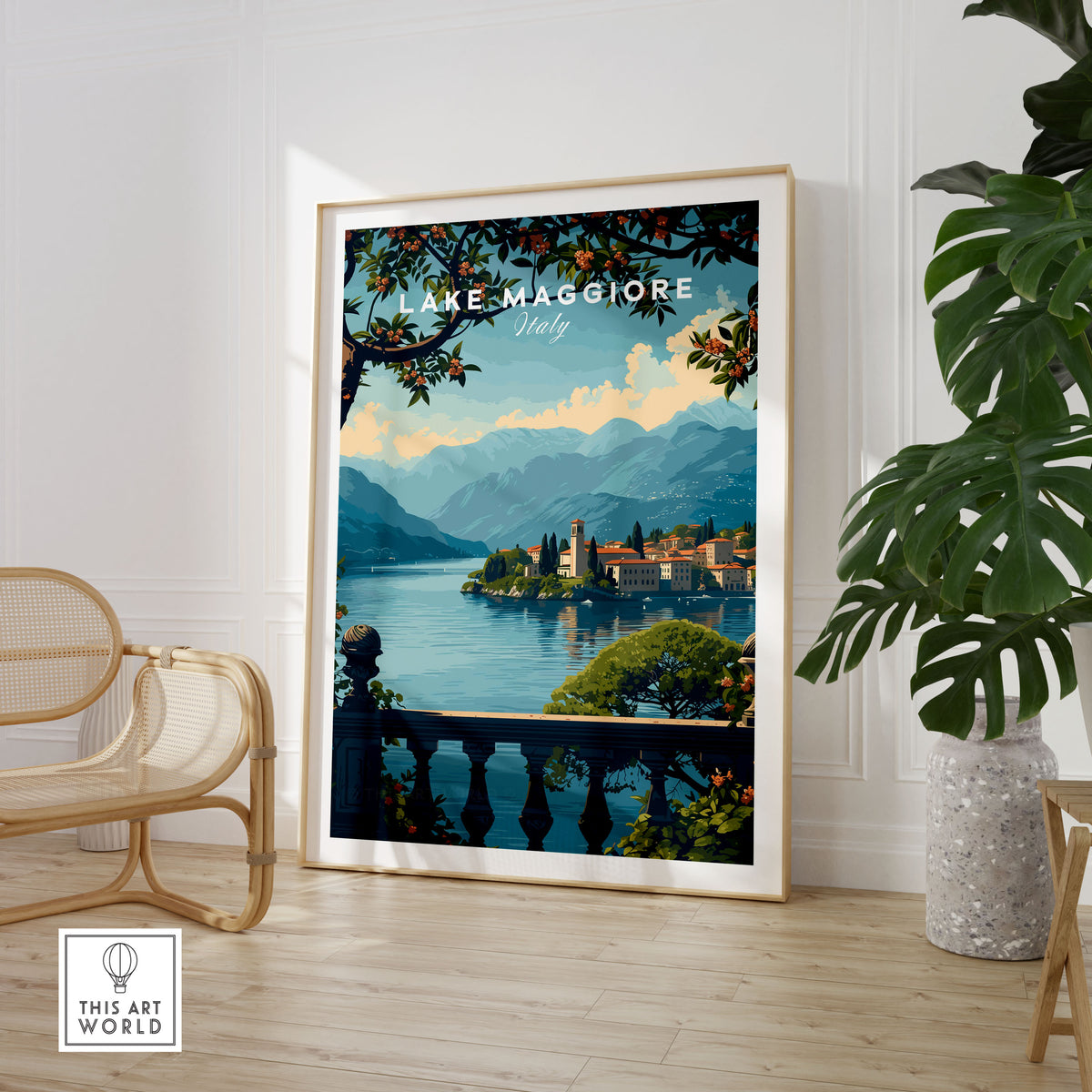 Lake Maggiore Travel Poster in a large natural wood frame leaning in a room with a rattan chair and monstera plant