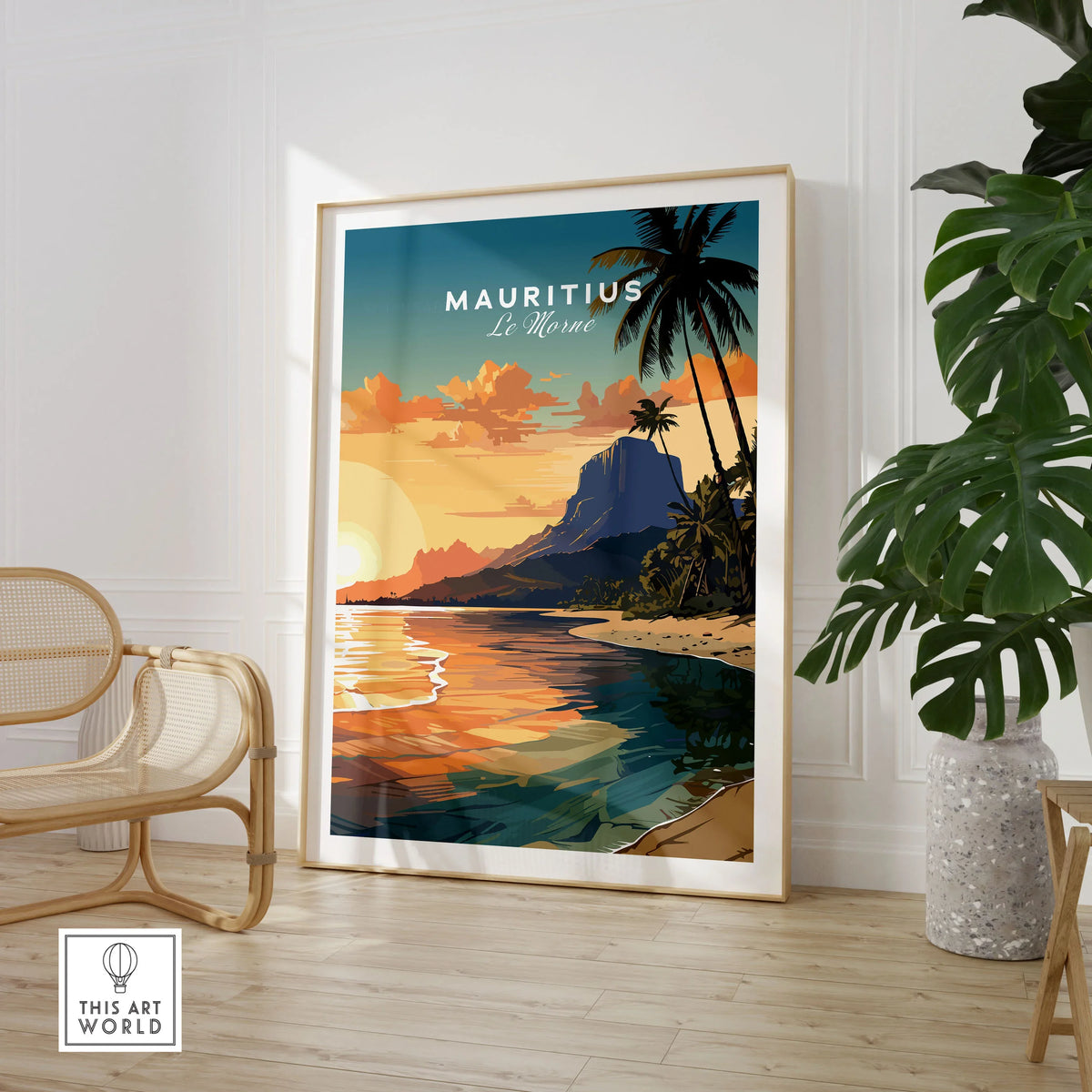 Le Morne Mauritius Poster in a large natural wood frame leaning in a room with a rattan chair and monstera plant