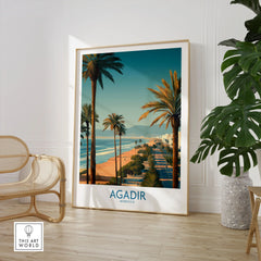 Agadir Morocco Wall Art Canvas in a large natural wood frame leaning in a room with a rattan chair and monstera plant