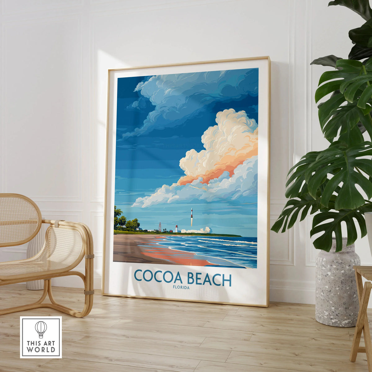 Cocoa Beach Kennedy Space Center Poster - Florida Wall Art Decor in a large natural wood frame leaning in a room with a rattan chair and monstera plant
