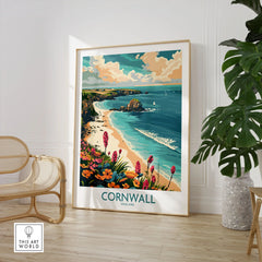 Cornwall Travel Poster - United Kingdom in a large natural wood frame leaning in a room with a rattan chair and monstera plant