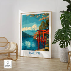 Hakone Wall Art Japan Red Torii Gate Poster in a large natural wood frame leaning in a room with a rattan chair and monstera plant
