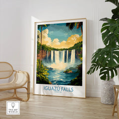 Iguazu Falls Wall Art Print in a large natural wood frame leaning in a room with a rattan chair and monstera plant