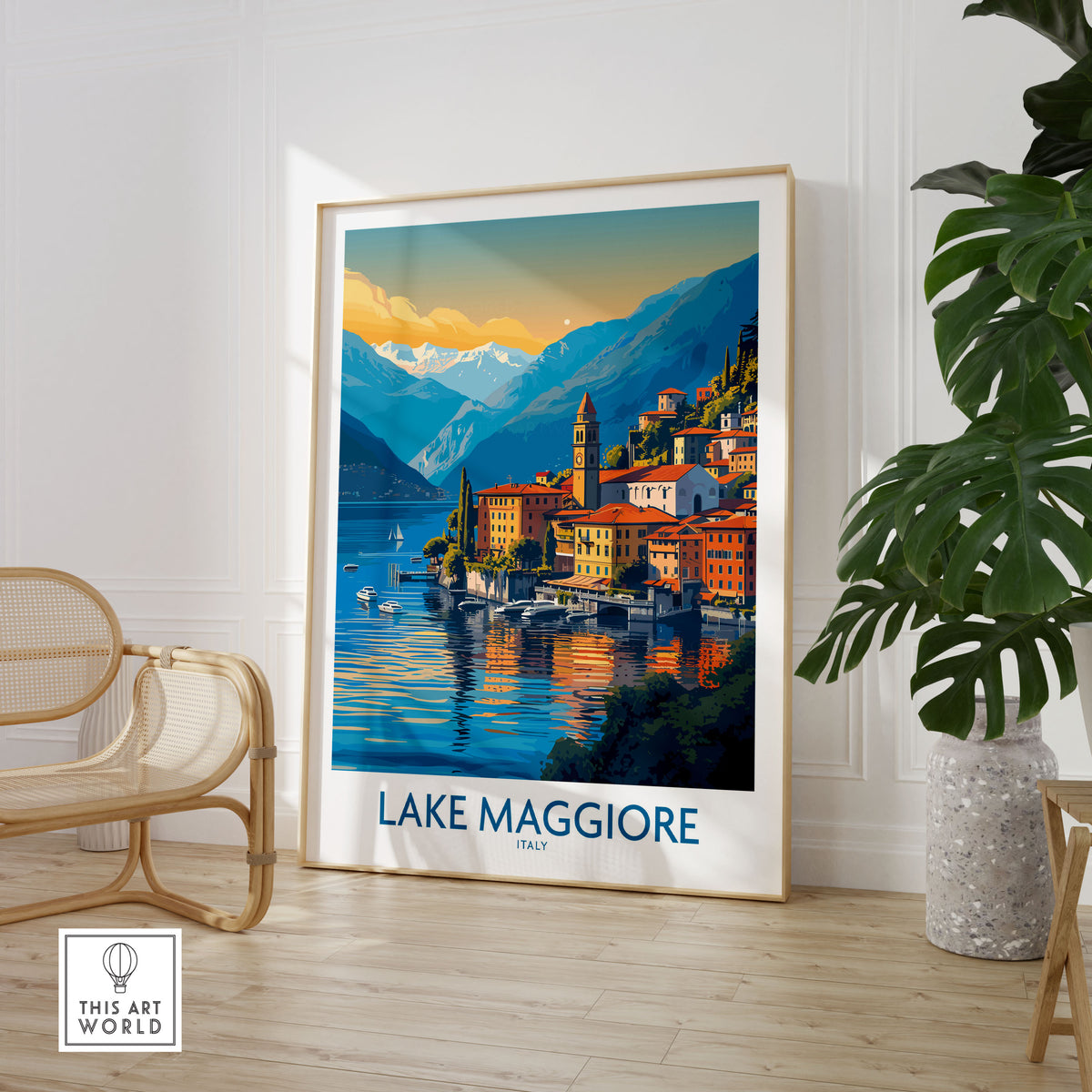 Lake Maggiore Italy Poster in a large natural wood frame leaning in a room with a rattan chair and monstera plant