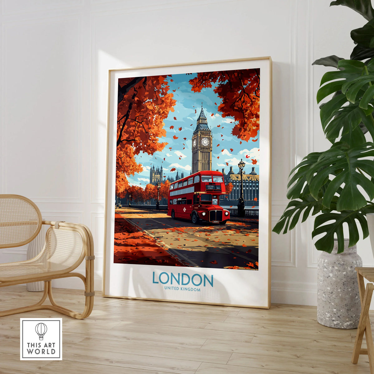 London Travel Poster in a large natural wood frame leaning in a room with a rattan chair and monstera plant