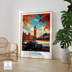 London Wall Art Print - Modern in a large natural wood frame leaning in a room with a rattan chair and monstera plant