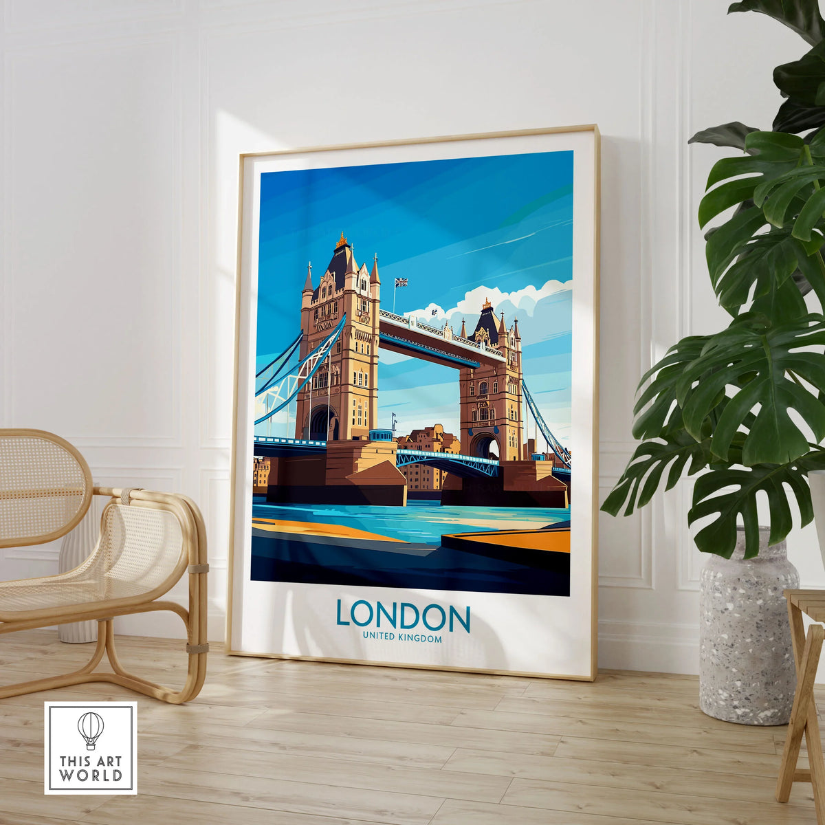 London Poster England in a large natural wood frame leaning in a room with a rattan chair and monstera plant