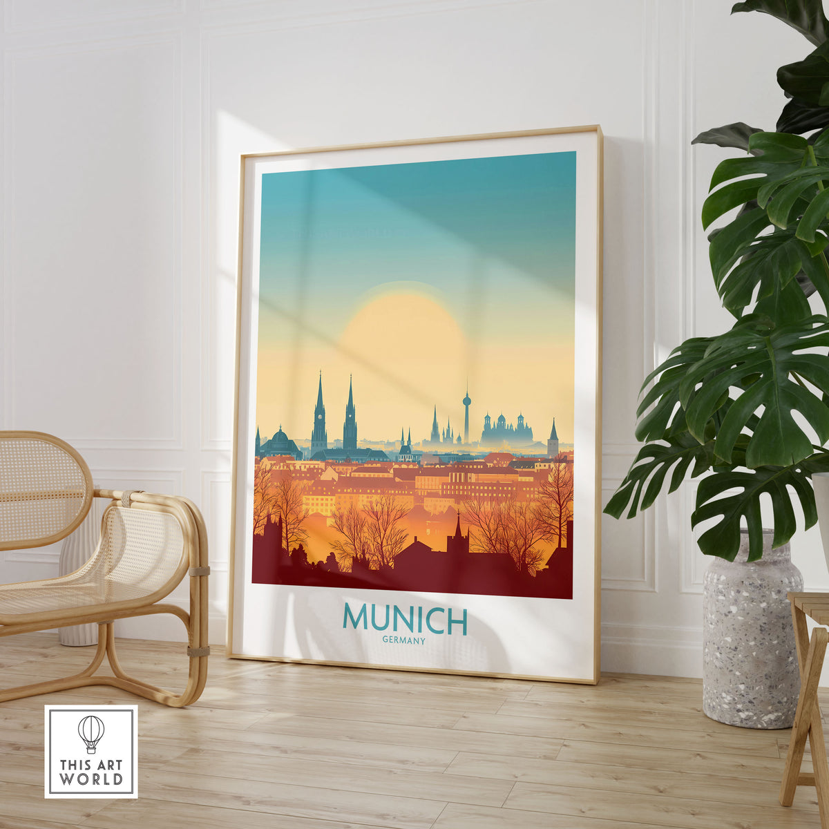 Munich Print Germany in a large natural wood frame leaning in a room with a rattan chair and monstera plant