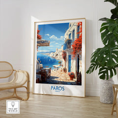 Paros Wall Art Greece in a large natural wood frame leaning in a room with a rattan chair and monstera plant