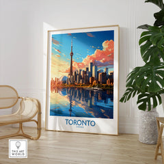 Toronto Wall Art Print in a large natural wood frame leaning in a room with a rattan chair and monstera plant