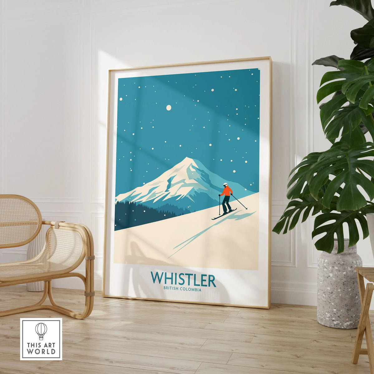 Whistler Wall Art Print -  British Columbia in a large natural wood frame leaning in a room with a rattan chair and monstera plant