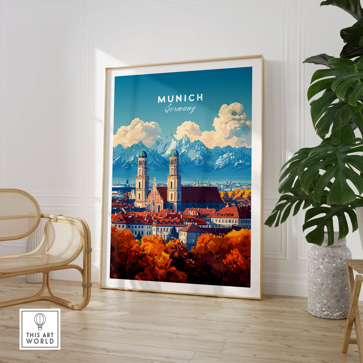 Munich Travel Print in a large natural wood frame leaning in a room with a rattan chair and monstera plant