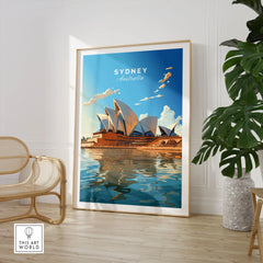 Sydney Poster Australia in a large natural wood frame leaning in a room with a rattan chair and monstera plant