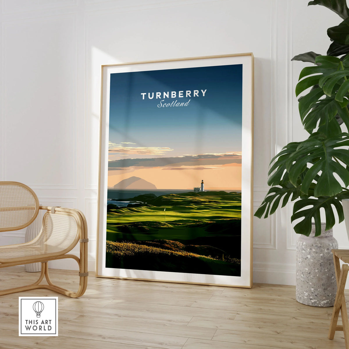 Turnberry Scotland Ailsa Craig Travel Poster — Ailsa Craig and the white lighthouse across rolling coastal turf at dusk, shown as large framed print room setting chair plant