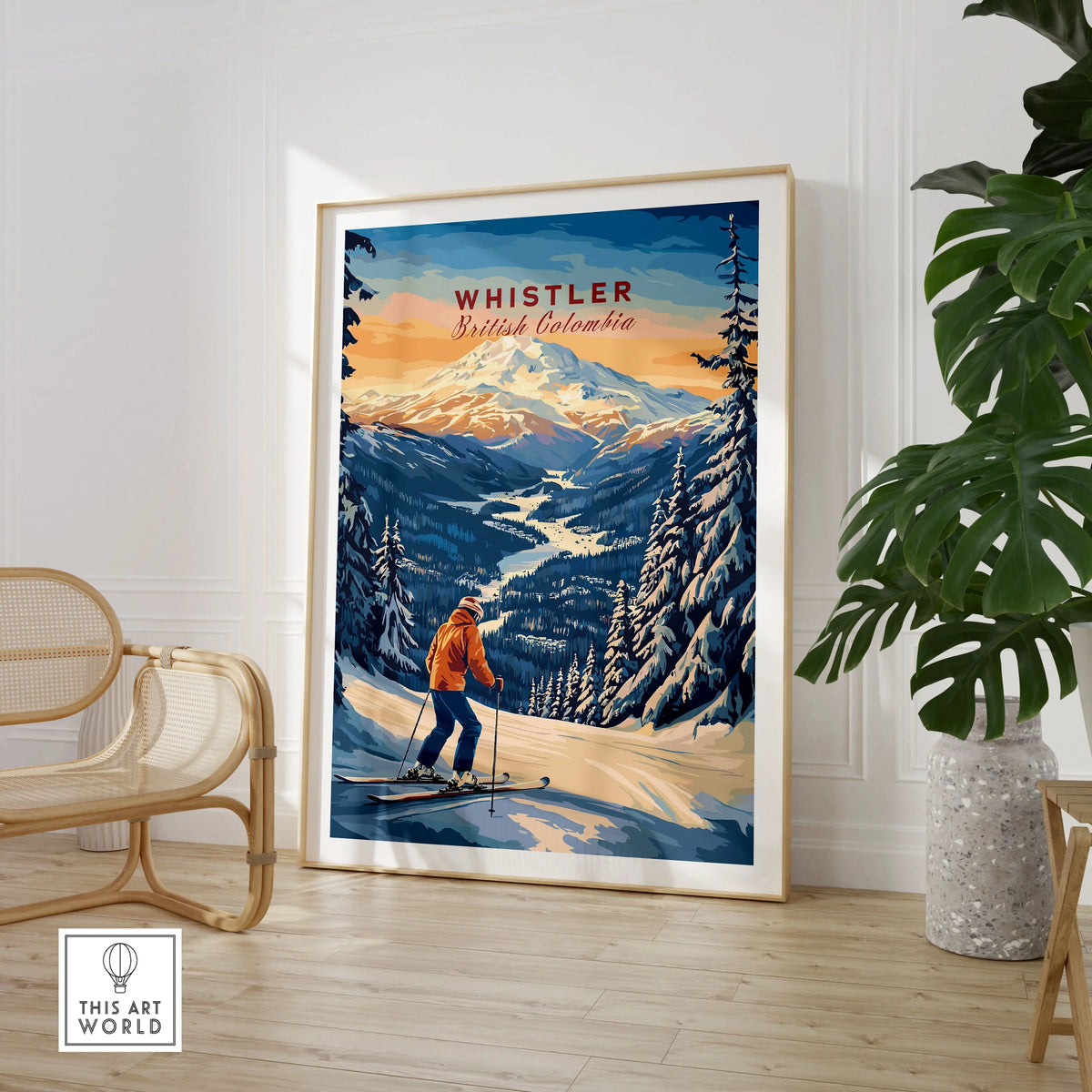 Whistler Travel Poster -  British Columbia in a large natural wood frame leaning in a room with a rattan chair and monstera plant