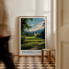 Framed Balmoral Castle travel poster with scenic landscape on floor in modern home entryway.