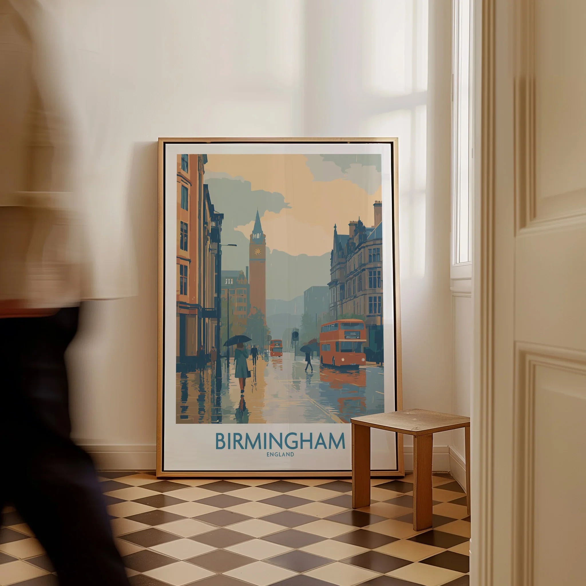 Framed Birmingham city art print on floor in modern home entryway, person walking by