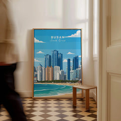 Framed Busan South Korea city skyline travel poster on floor in bright hallway