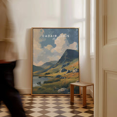 Framed Cadair Idris travel art print leaning on floor in bright, modern room with checkered tiles.
