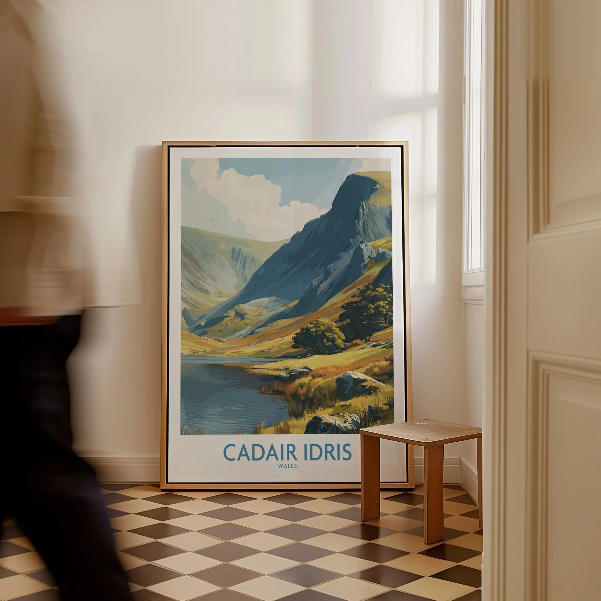 Framed Cadair Idris Wales travel poster on checkered floor, man walking past