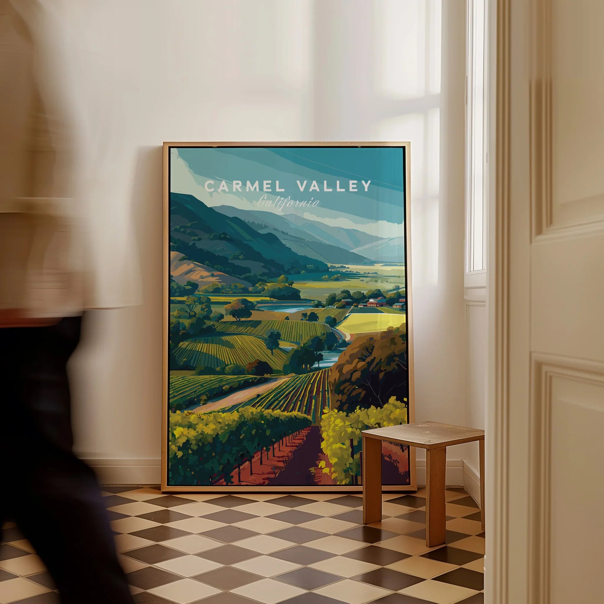 Framed Carmel Valley California travel poster with vineyard art on floor, man walking past