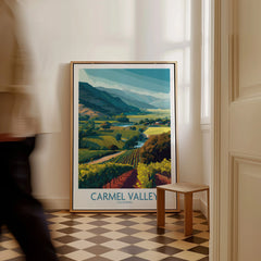Carmel Valley California travel poster in frame on checkered floor, man walking past.