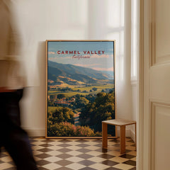 Framed Carmel Valley California travel poster leaning against wall in modern home interior