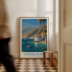 Framed Catalina Island travel poster with ocean view and boats, placed on a checkered floor.