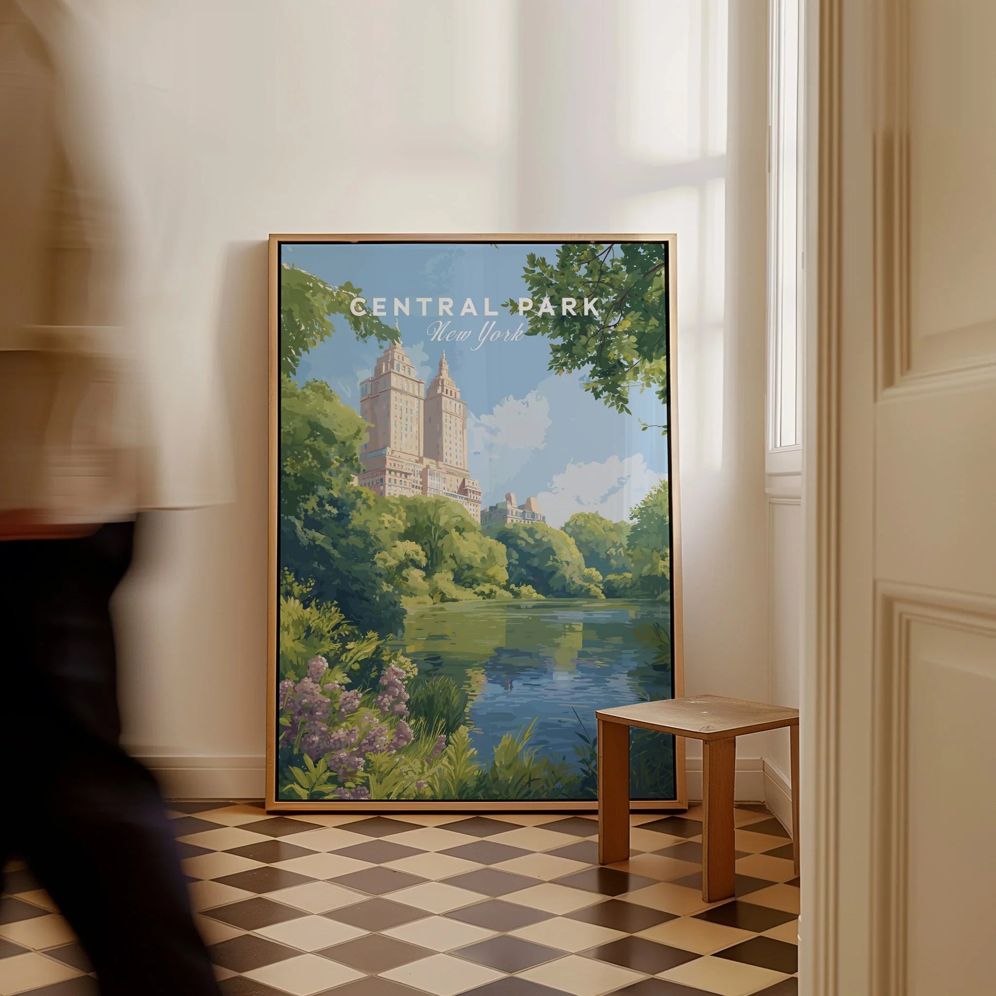 Framed Central Park New York cityscape wall art on floor, man walking past in hallway