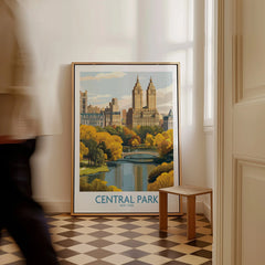 Framed Central Park New York art print resting on floor, cityscape and autumn trees visible.