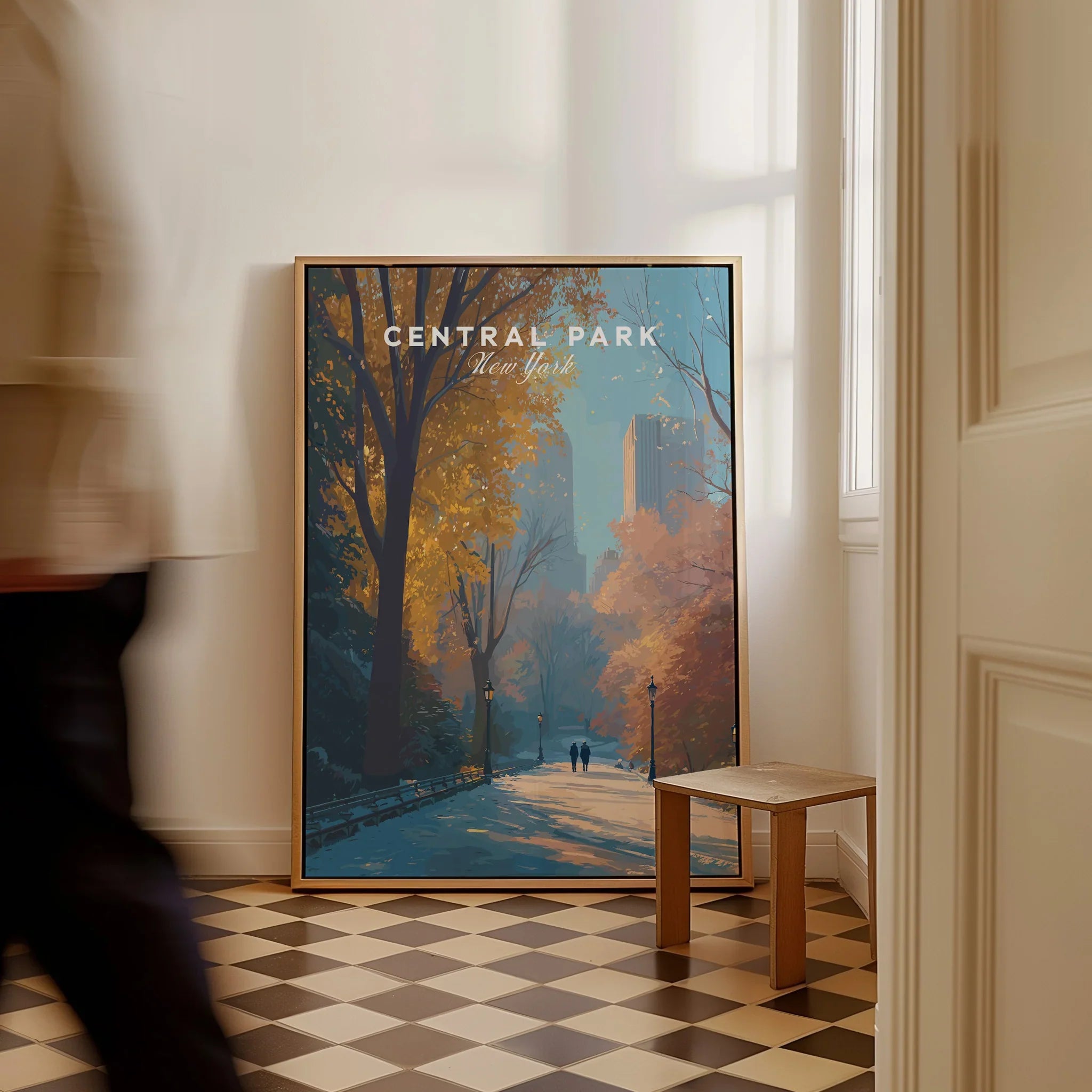 Framed Central Park New York travel poster with autumn trees leaning against a wall indoors.