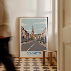 Colchester England travel poster framed on checkered floor, man walking past in hallway