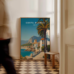 Costa Blanca Travel Poster - Spain Canvas Print featuring coastal scenery and vibrant colors in a stylish indoor setting.