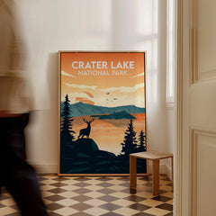 Framed Crater Lake National Park art print on floor, sunrise landscape with deer and trees.