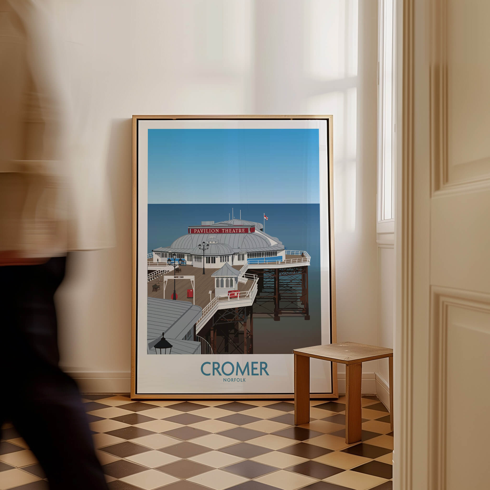 Cromer Norfolk Wall Art – Historic Seaside Pier Art Print displayed in a stylish interior setting next to a wooden stool.