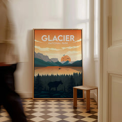 Framed Glacier National Park travel poster with sunset landscape on floor, man walking past