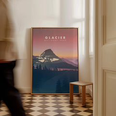 Framed Glacier National Park travel poster with mountain art on floor, man walking past