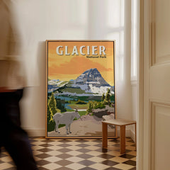 Framed Glacier National Park travel poster with mountain and goat, displayed on floor in a hallway.