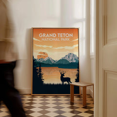 Grand Teton National Park framed travel poster with sunset, mountains, and elk, on floor.