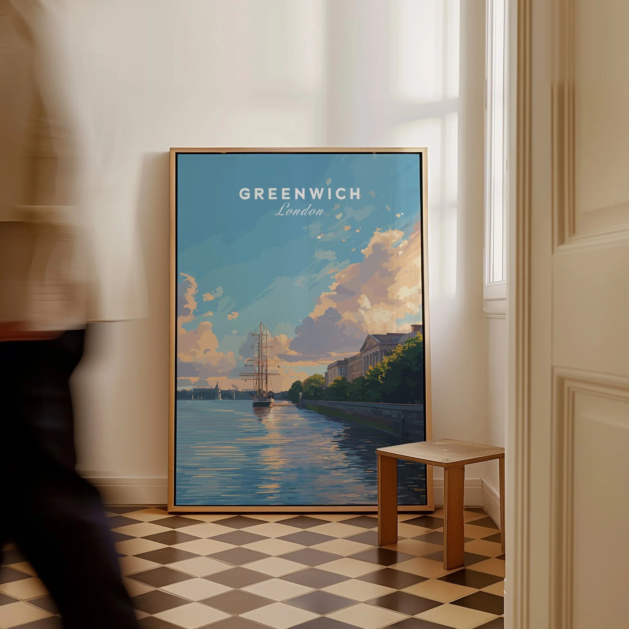 Framed Greenwich London travel poster leaning on wall with a person walking past