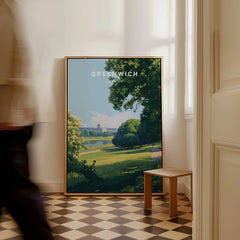 Greenwich London travel poster framed, leaning on wall in bright interior with person walking past.