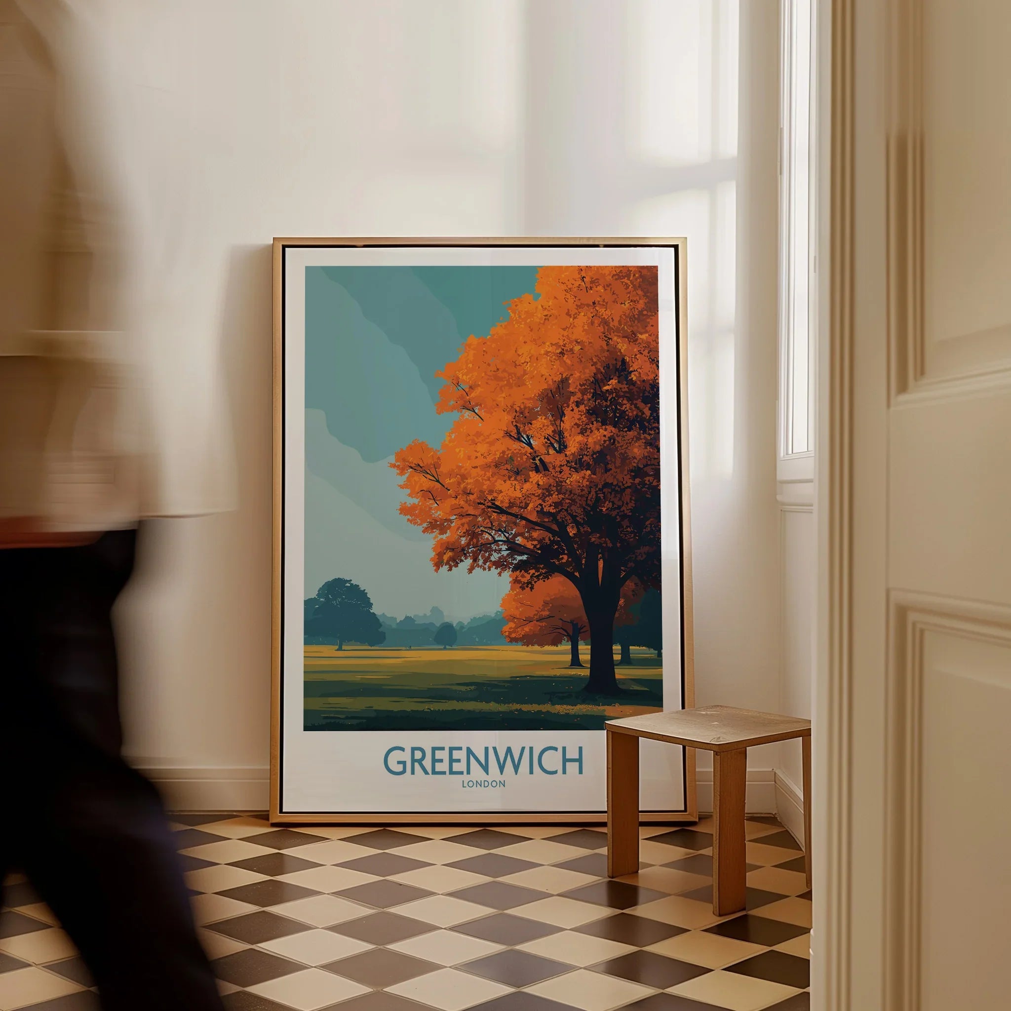 Framed Greenwich London travel poster with autumn tree resting on checkered floor, man walking past.