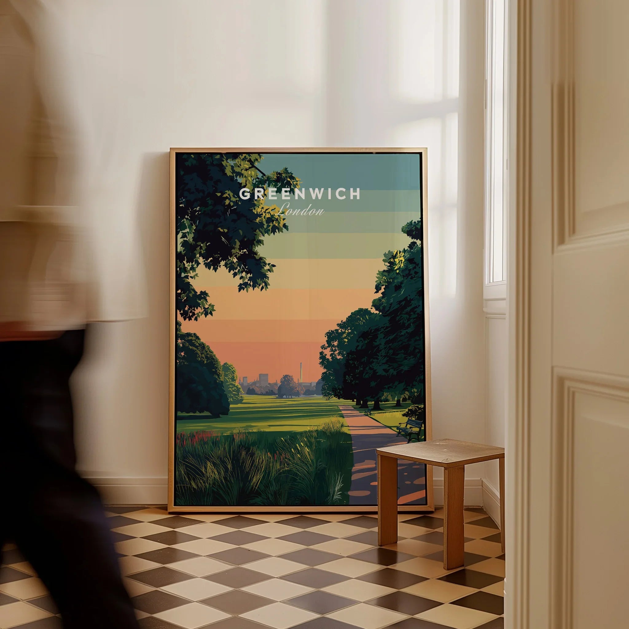 Framed Greenwich London travel poster leaning on wall in sunlit hallway with checkered floor