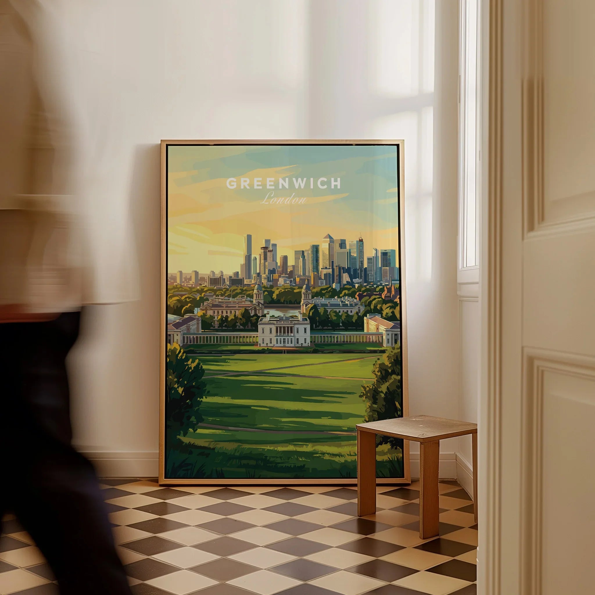 Framed Greenwich London travel poster on floor, man walking past in modern entryway