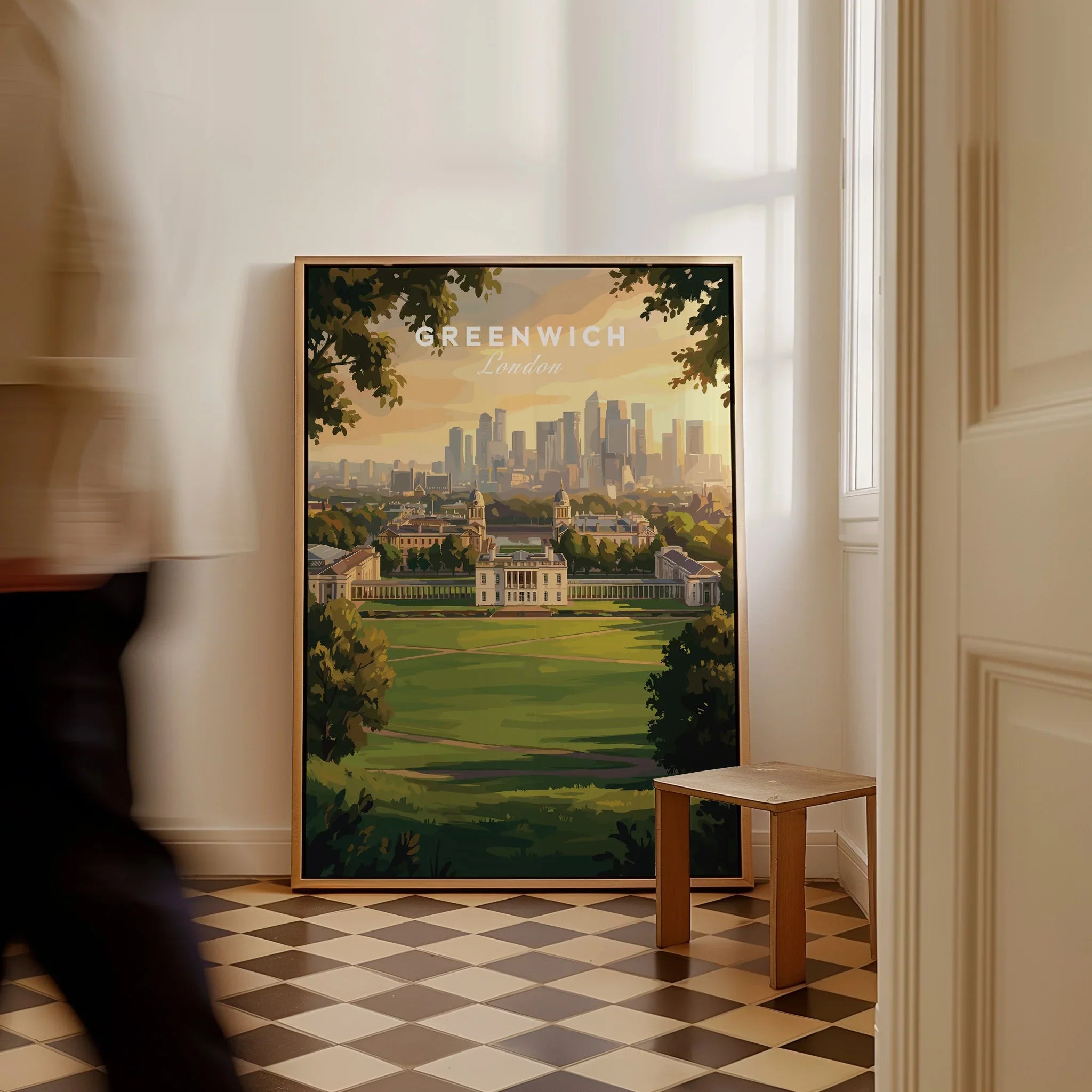 Framed Greenwich London travel poster on floor, city skyline artwork in sunlit hallway
