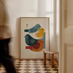 Framed minimalist art print of colorful birds on floor in bright modern hallway