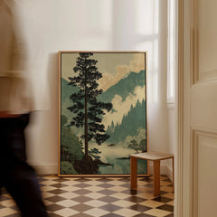 Framed Japanese woodblock landscape art print with pine tree and mountains, leaning on floor