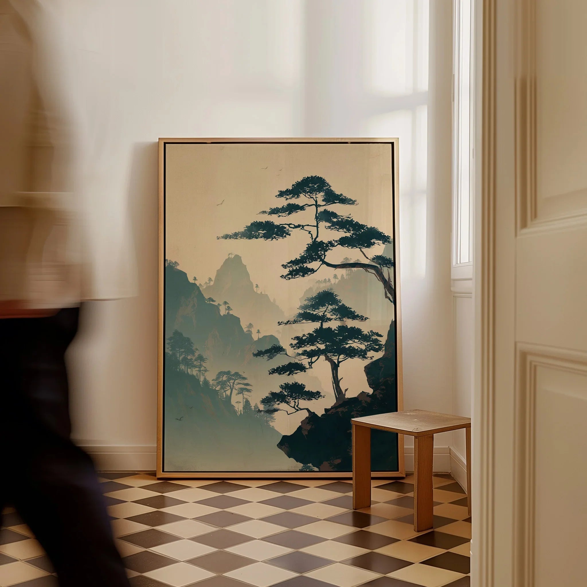 Framed Japanese woodblock wall art with misty mountains and trees, resting on checkered floor