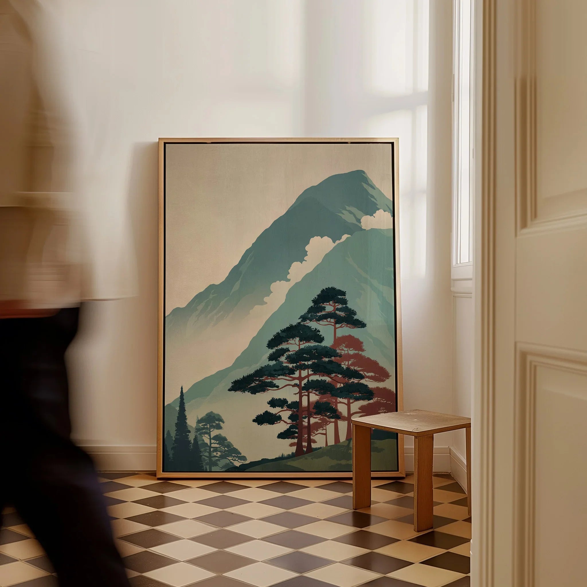 Framed Japanese mountain landscape print on checkered floor, pine trees in foreground.